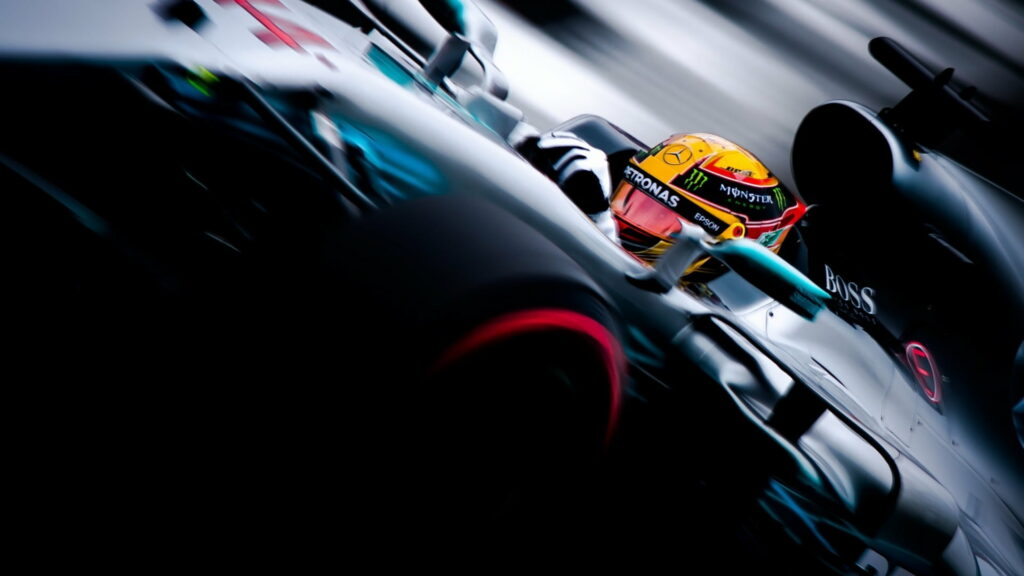 Lewis Hamilton Mercedes F1 car with yellow helmet racing at high speed HD wallpaper background