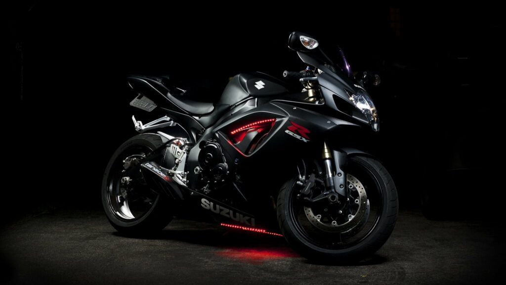 Black Suzuki GSX-R sportbike with red LED underglow on dark background QHD wallpaper