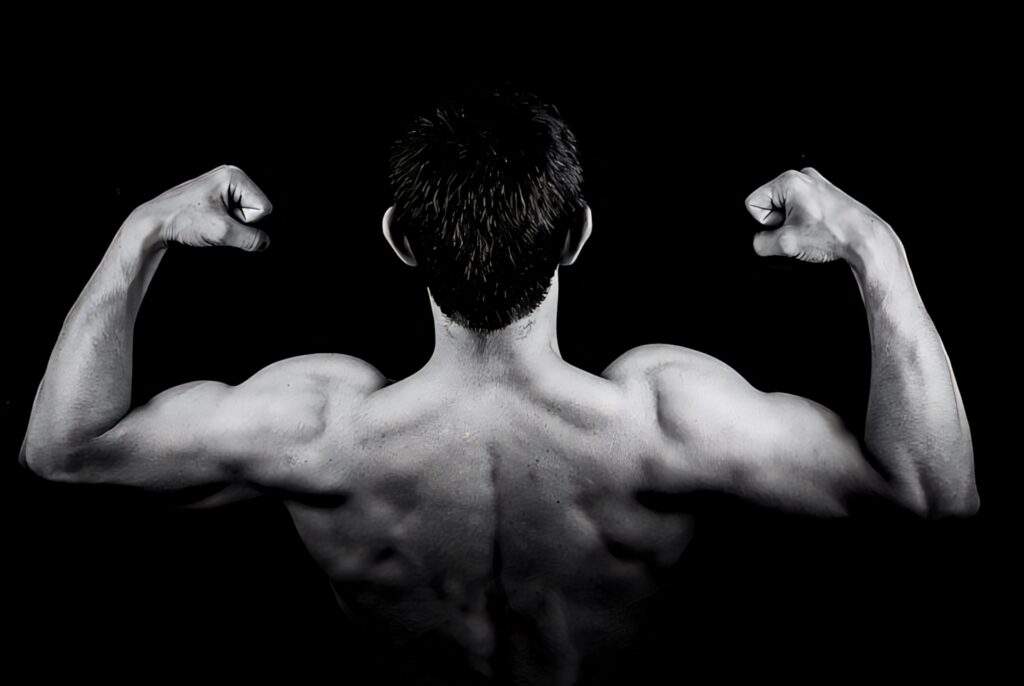 Black and white HD wallpaper of muscular bodybuilder flexing arms showing strength and definition