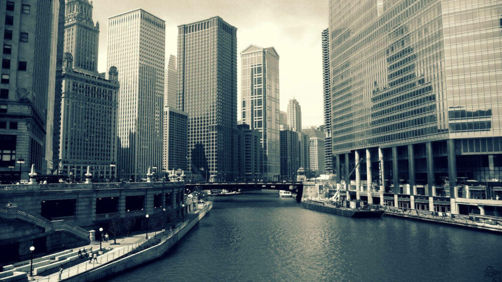 Black and white Chicago skyline wallpaper with historic and modern skyscrapers reflected in river