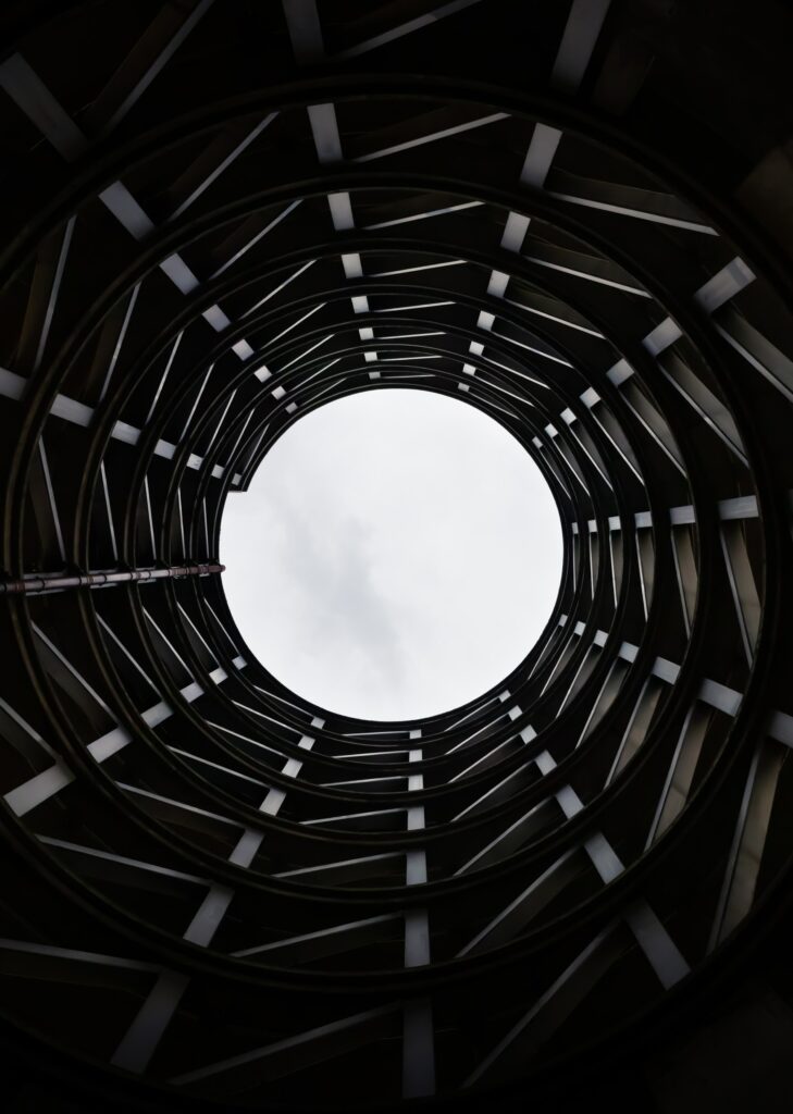 Stunning Black and White Wallpaper: Circular Building Under Cloudy Sky