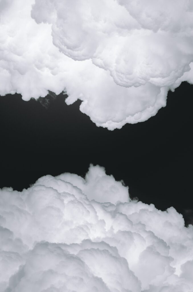 Fluffy Clouds on Dark Background: Striking Black and White Wallpaper