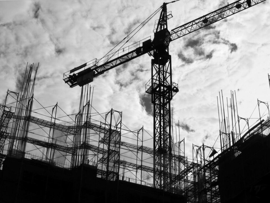 Black and white silhouette of construction site with crane steel framework and scaffolding wallpaper