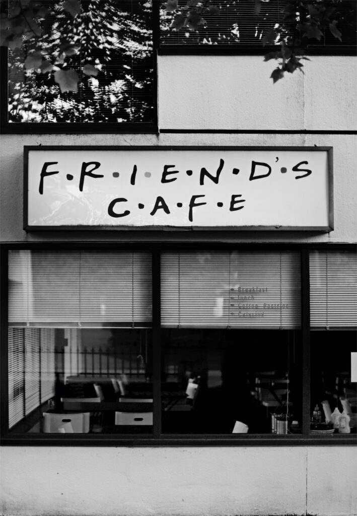 Black and White Wallpaper: Friends Cafe Signboard with Reflective Windows