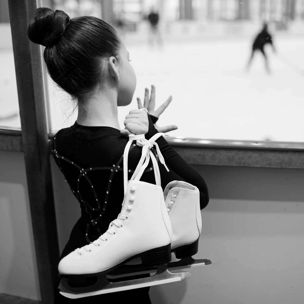 Young Girl with Ice Skates: Serene Black & White Wallpaper