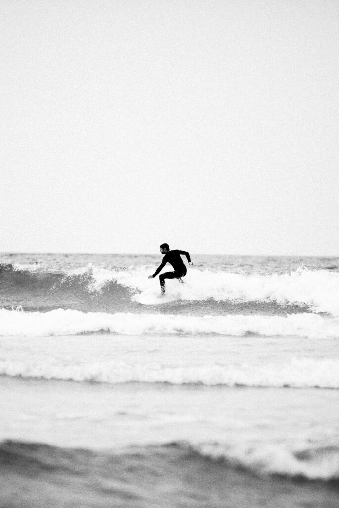 Monochrome Surfer Riding Waves: Dynamic Black and White Wallpaper