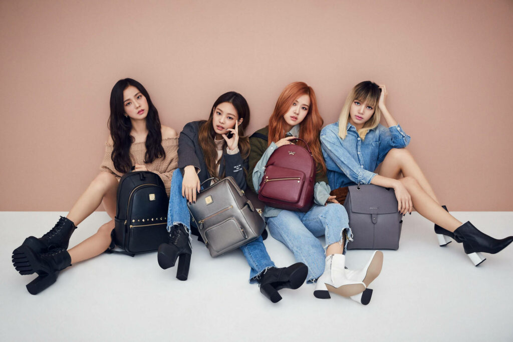 Stylish Blackpink Wallpaper: Fashionable Members on Tan Backdrop