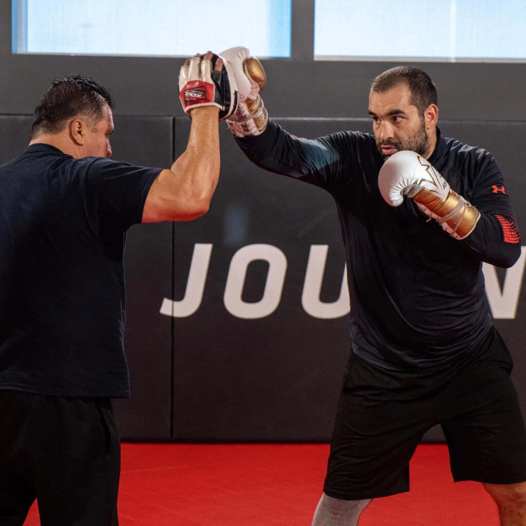Blagoy Ivanov boxing training with coach in professional gym focused on punching technique Wallpaper