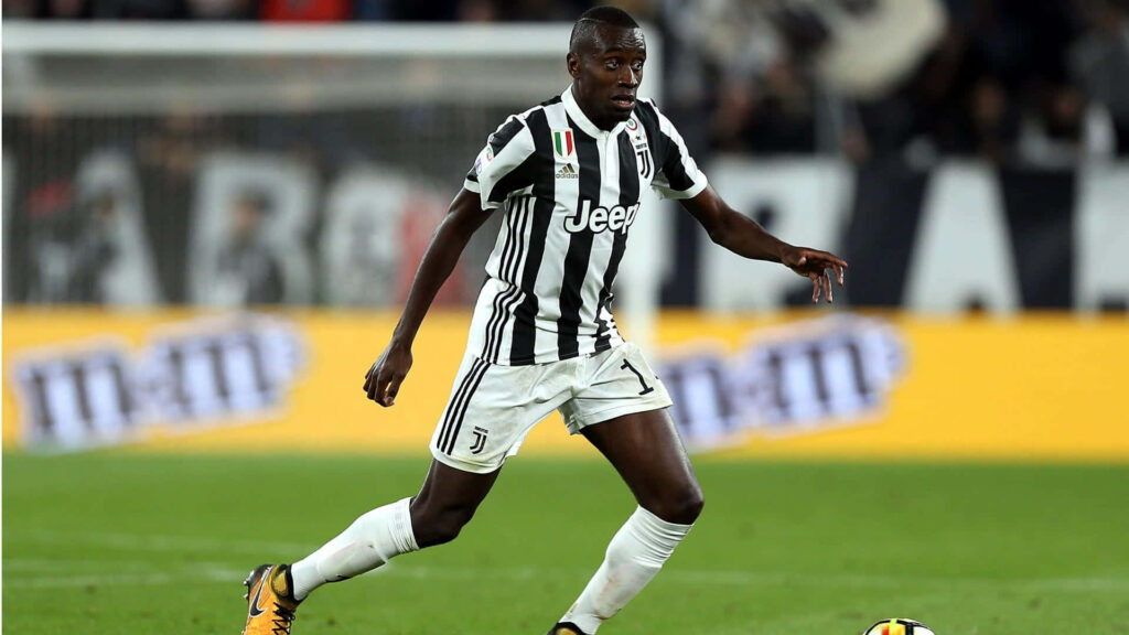 Midfielder Blaise Matuidi kicking the ball in Juventus kit during a soccer match wallpaper background