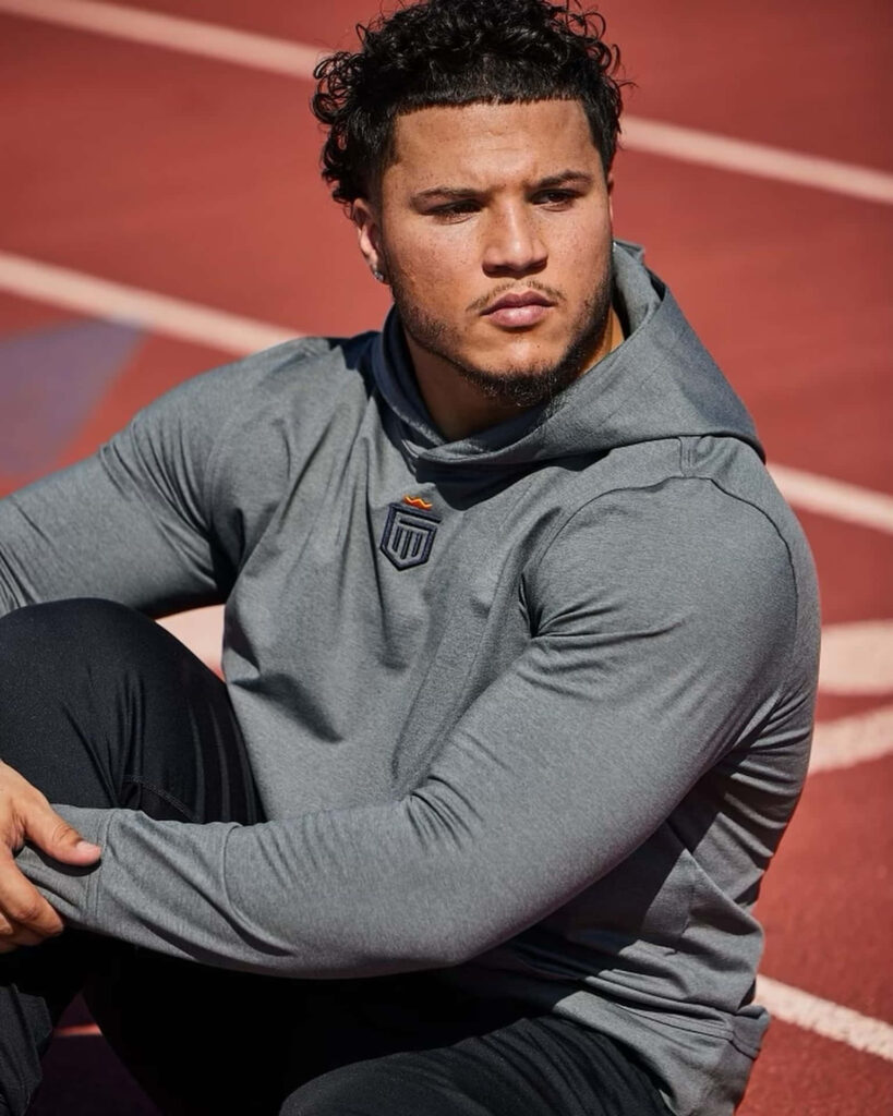 Blake Corum seated on track field showing athletic focus strength dynamic sports wallpaper background