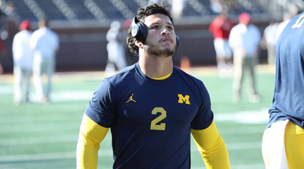 Blake Corum in Michigan football gear focused during pregame warmup with headphones on field Wallpaper