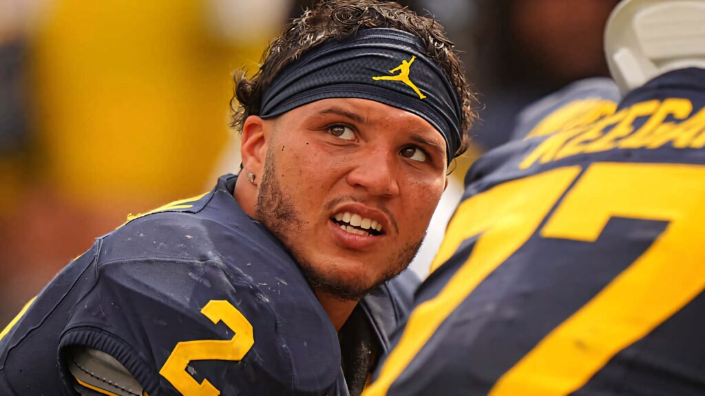 Blake Corum in Michigan Wolverines uniform focused intensely on the football sidelines wallpaper