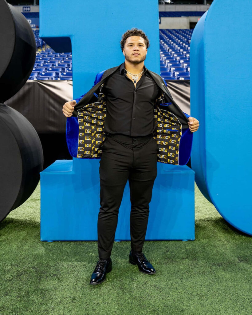 Blake Corum shows unique designer jacket lining with bold stadium background athletic style Wallpaper