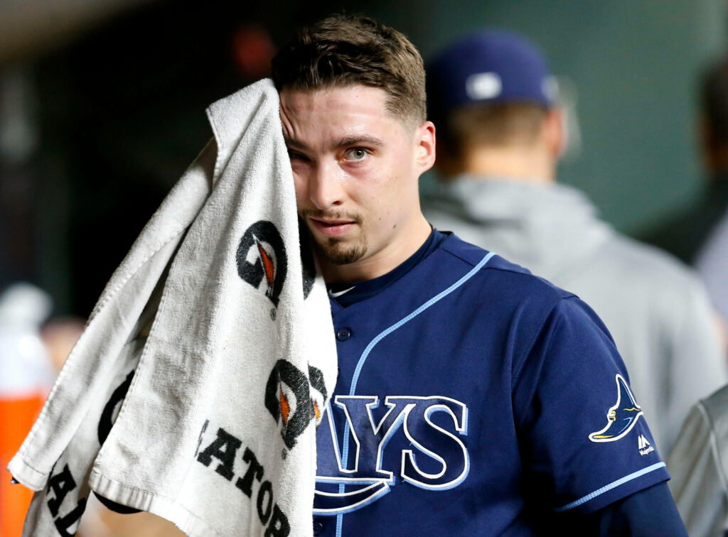 Blake Snell wiping sweat in Tampa Bay Rays uniform during intense baseball game candid moment Wallpaper