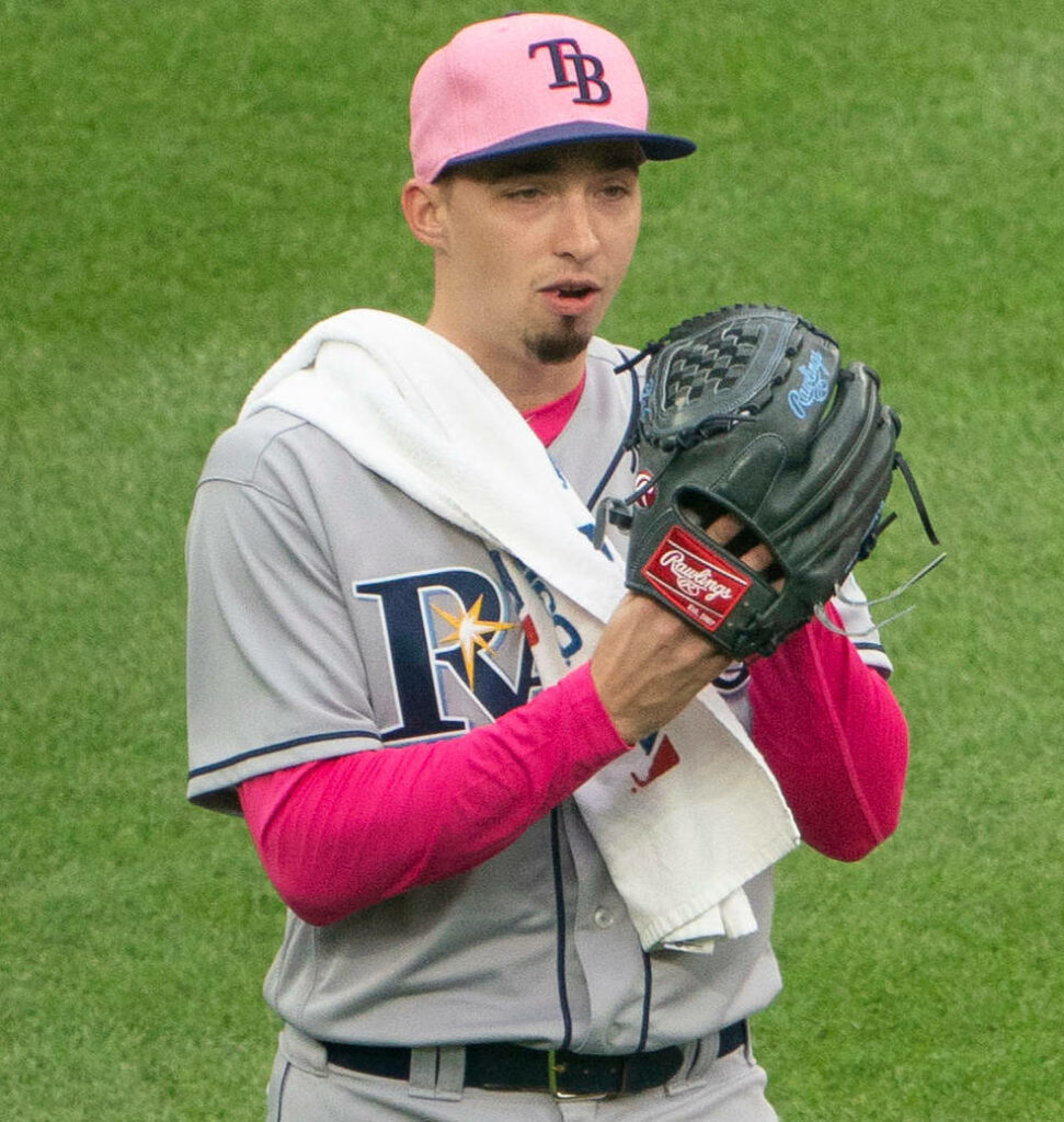 Blake Snell in Tampa Bay Rays uniform with pink cap and undershirt holding baseball glove on field Wallpaper