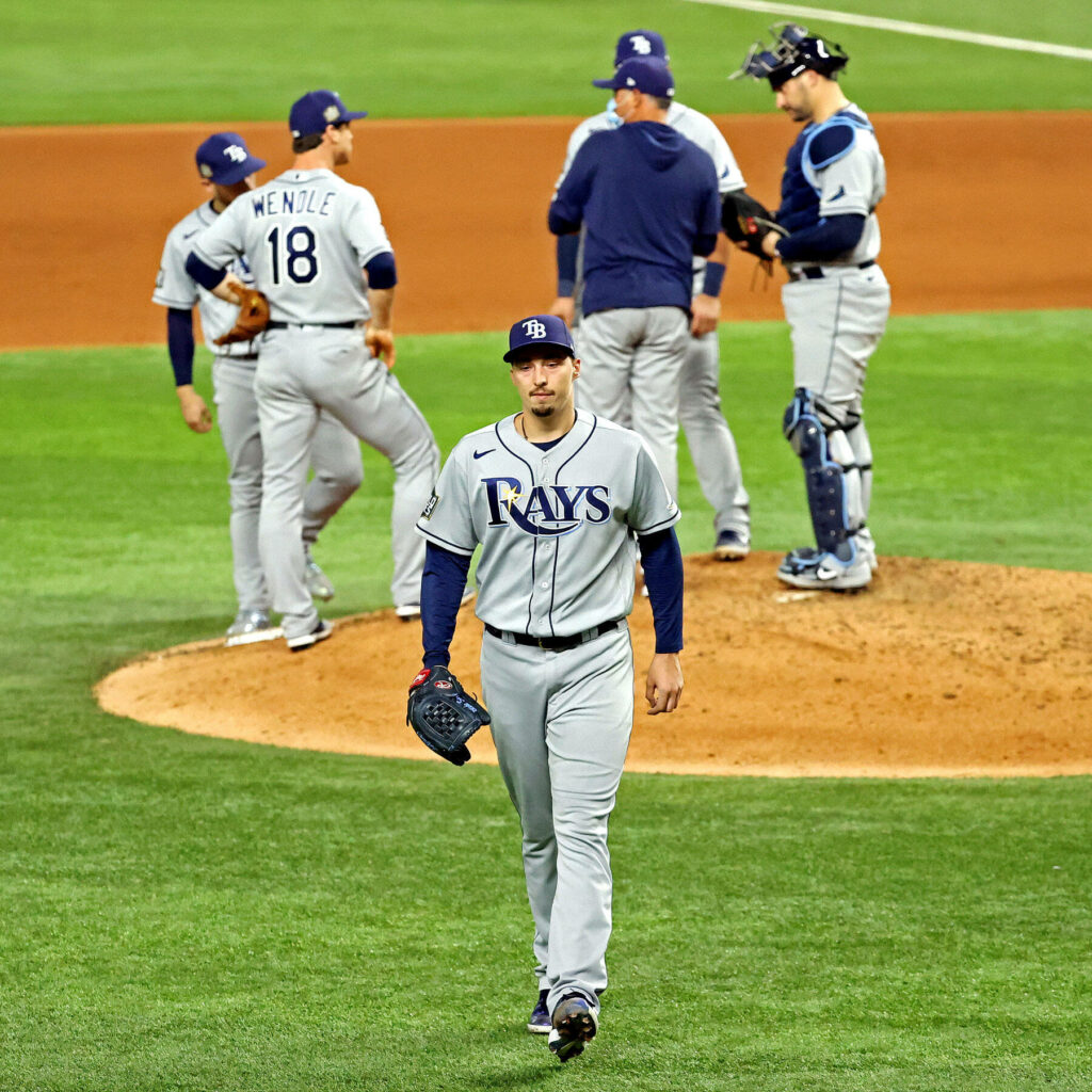 Blake Snell walking from pitchers mound focused Tampa Bay Rays teammates background baseball game Wallpaper