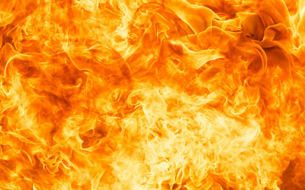 Intense orange fire flames with glowing yellow red hues dynamic swirling hot abstract background Wallpaper