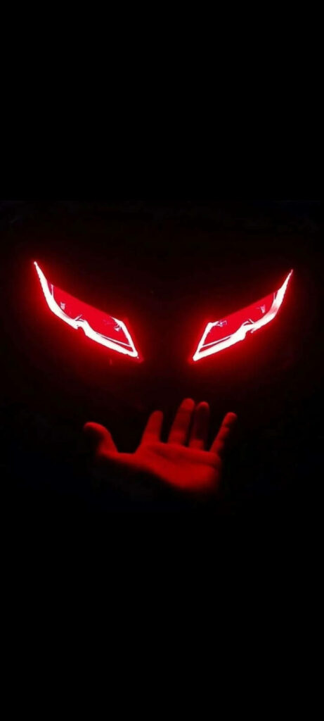 R15 V3 Motorcycle's Fiery Red Headlamp Captured Against a Mysterious Night Background Wallpaper