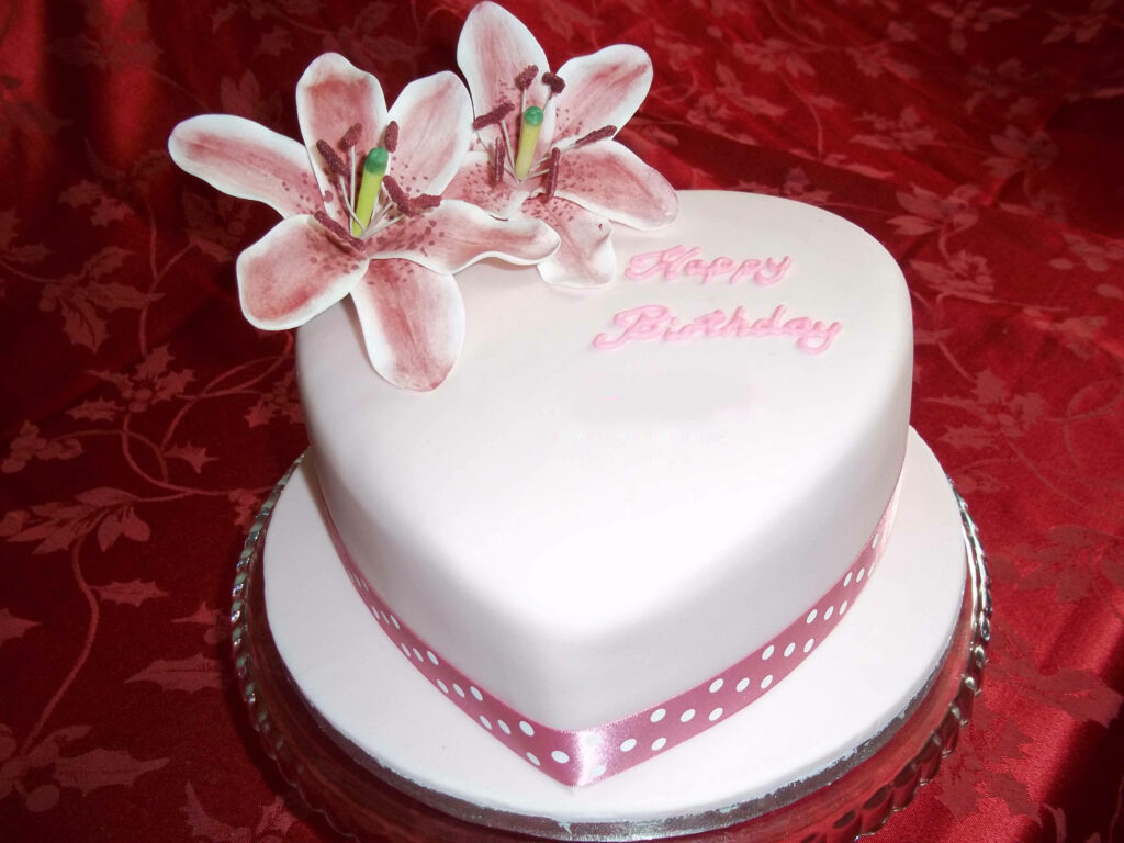 Blossoming Love: Captivating Heart-shaped Fondant Birthday Cake with Delicate Floral Accents on a Pristine White Frosting - Vibrant Birthday Cake Shot Wallpaper