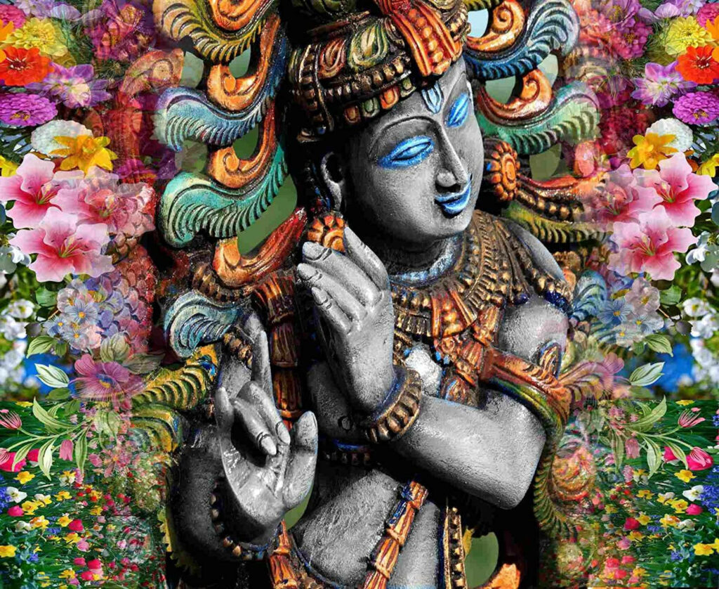 Divinely Adorned: Captivating Krishna Bhagwan Statue Amidst Floral Grandeur Wallpaper
