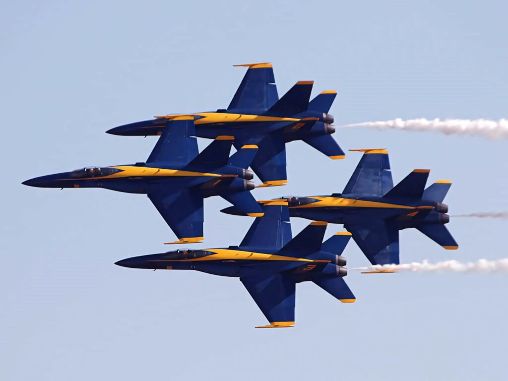 Blue Angels diamond formation flying in clear sky showcasing US Navy precision and teamwork Wallpaper