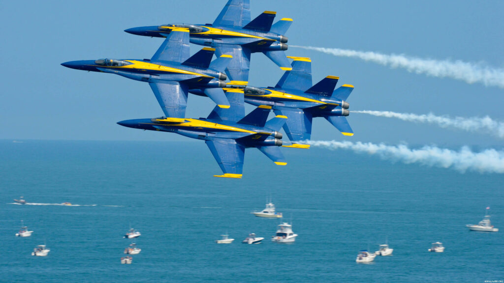 Blue Angels flying tight formation over sparkling ocean with boats clear sky dynamic wallpaper