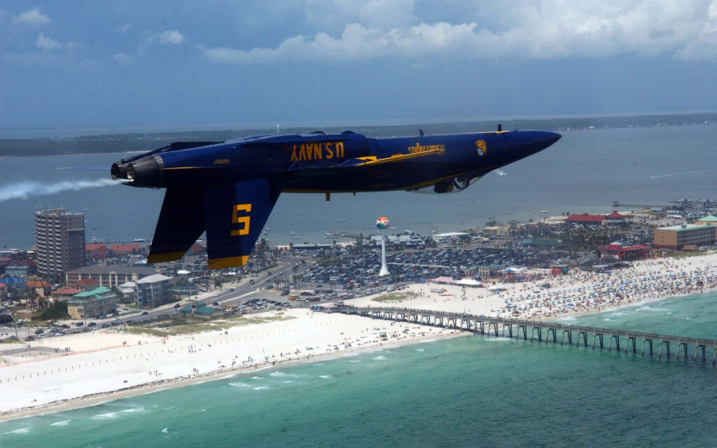 Blue Angels jet inverted flight over crowded beach showcasing US Navy precision aerial skills Wallpaper