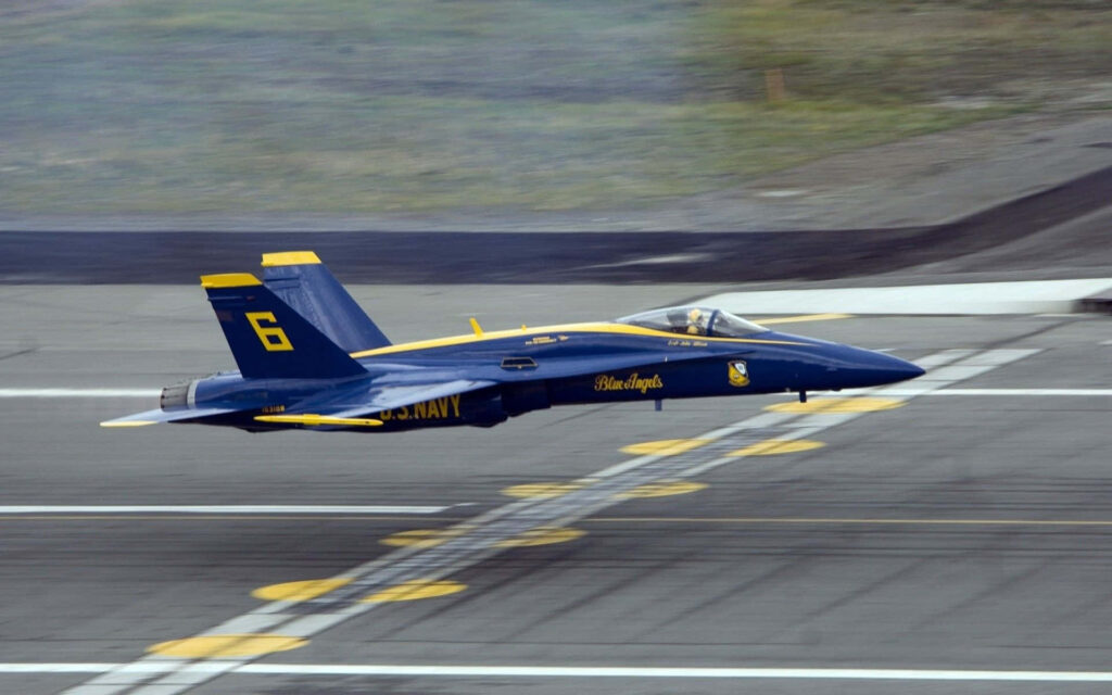Blue Angels jet in low-level flight displaying precision and power US Navy demonstration team Wallpaper