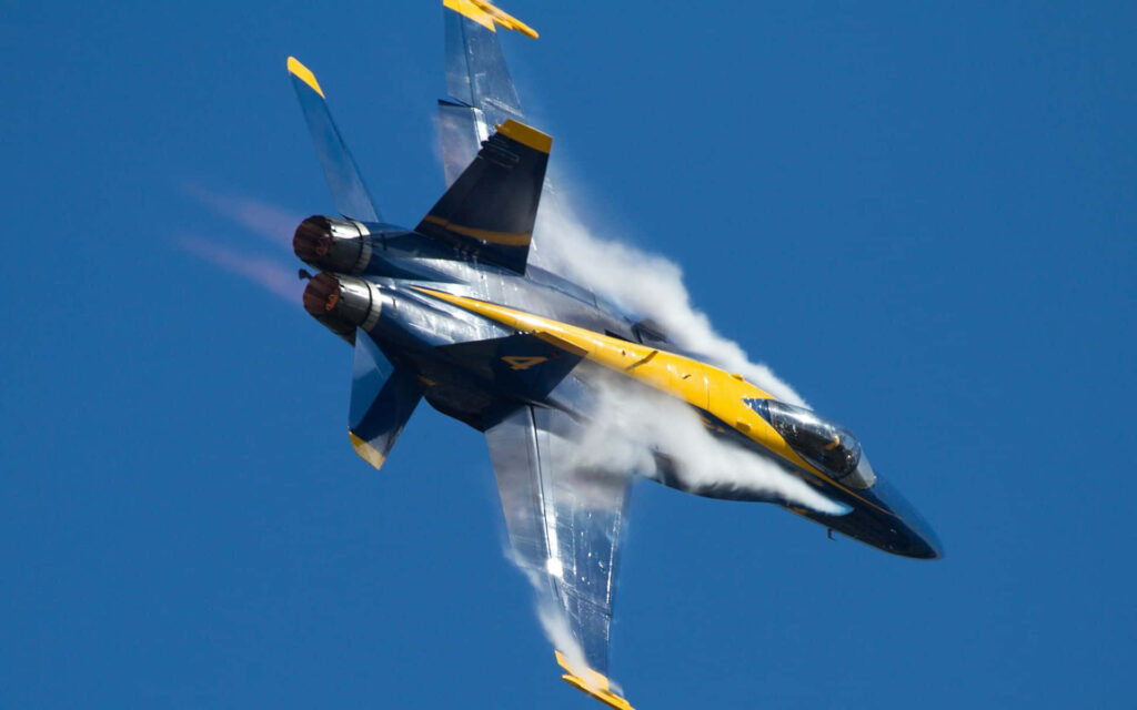 Blue Angels jet flying fast in clear blue sky showcasing sleek design aviation wallpaper
