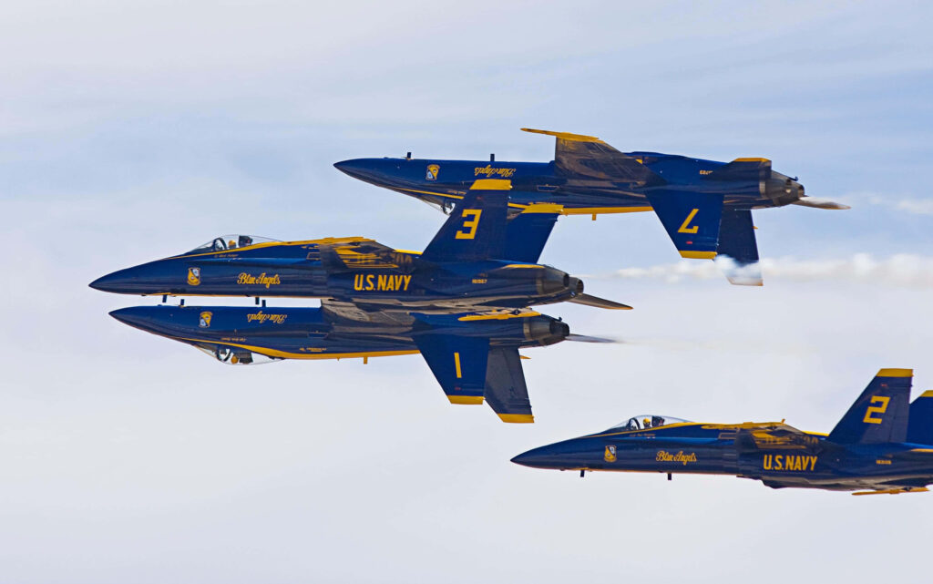 Three Blue Angels jets flying close formation in clear sky showcasing Navy squadron skill Wallpaper