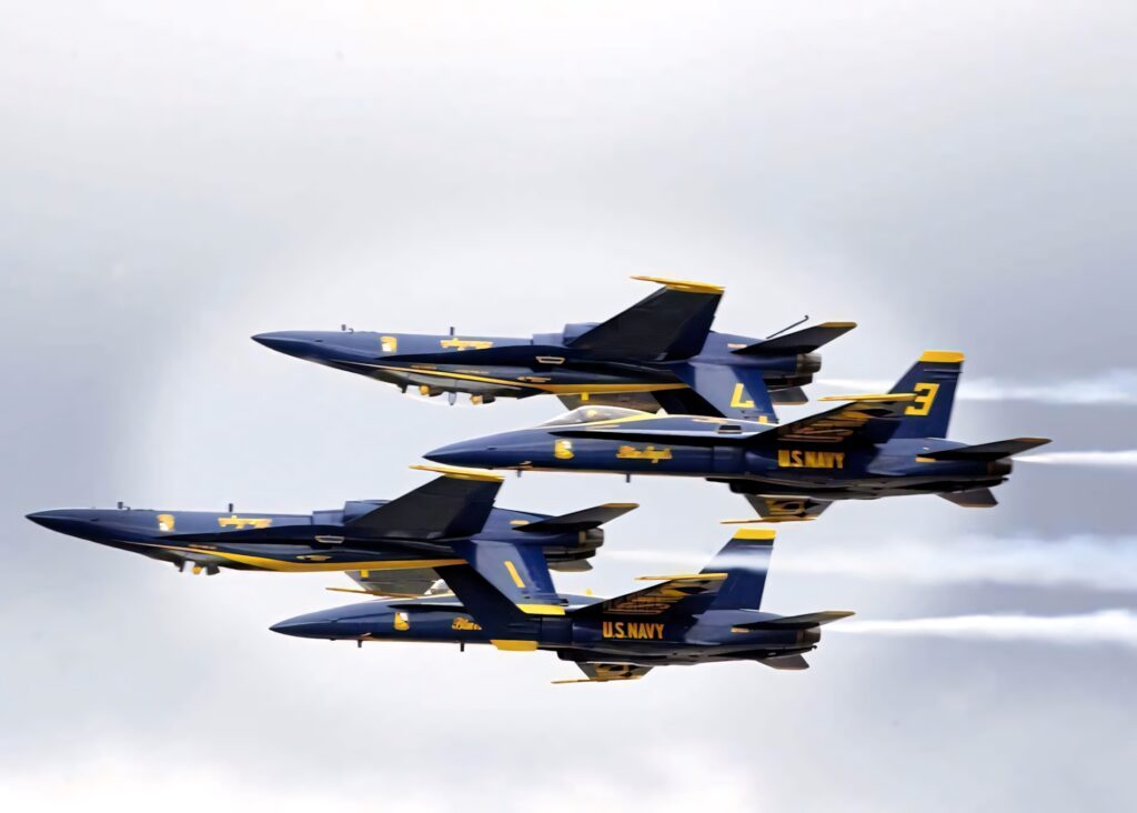 Four Blue Angels jets flying in tight formation over cloudy sky US Navy flight team wallpaper