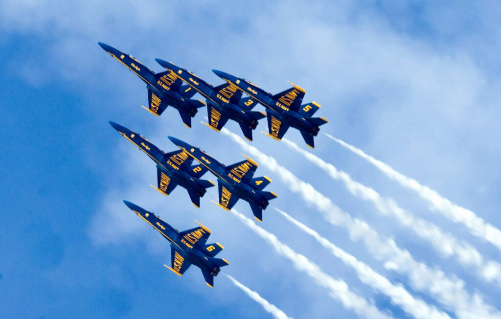 Blue Angels jet team flying in tight formation against clear blue sky dynamic aviation wallpaper