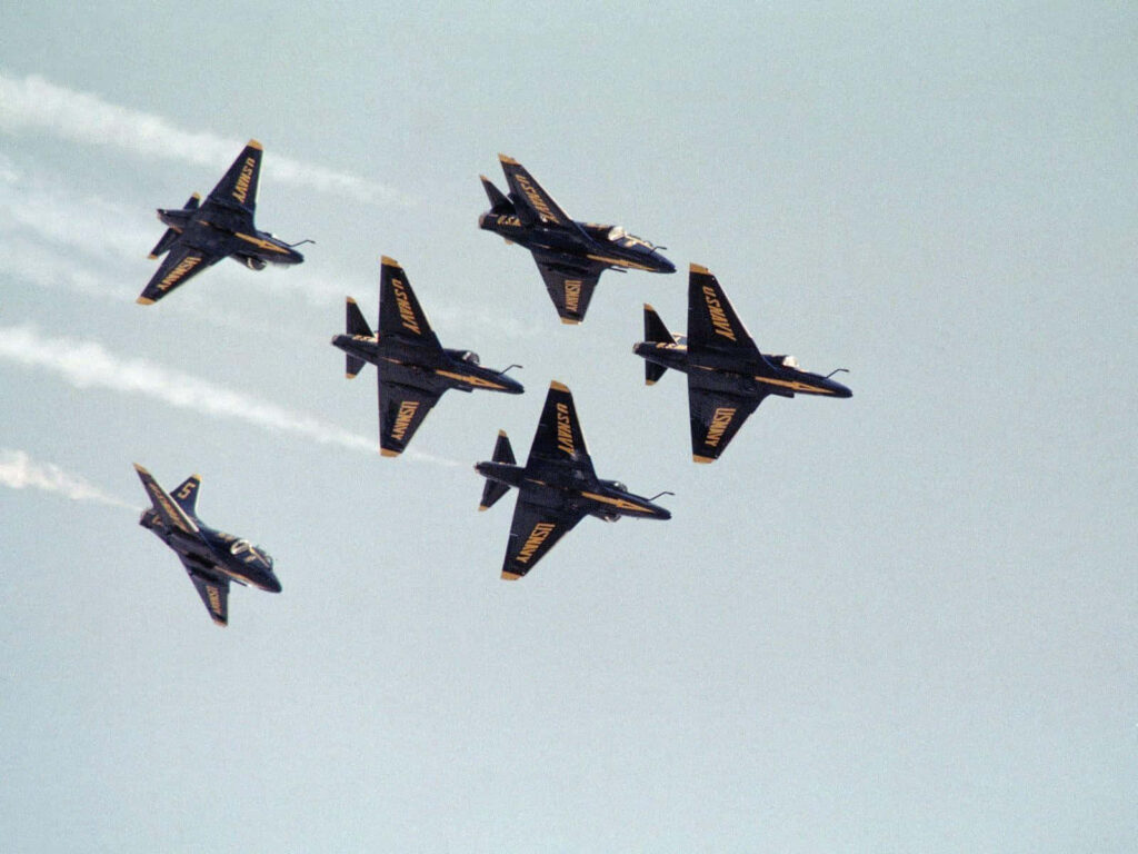 U.S. Navy Blue Angels jets flying precise tight formation against clear blue sky wallpaper