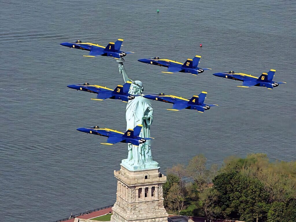 Blue Angels jet team flying over Statue of Liberty with water background vibrant sky wallpaper