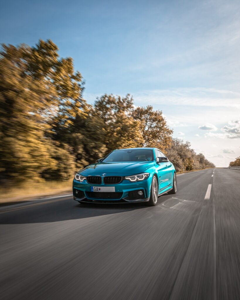 Dynamic Blue BMW M3 Wallpaper: Speeding Along Scenic Open Road