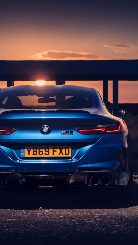 Sunset Elegance: Captivating 4K Background with Blue BMW M8 Model Car Wallpaper