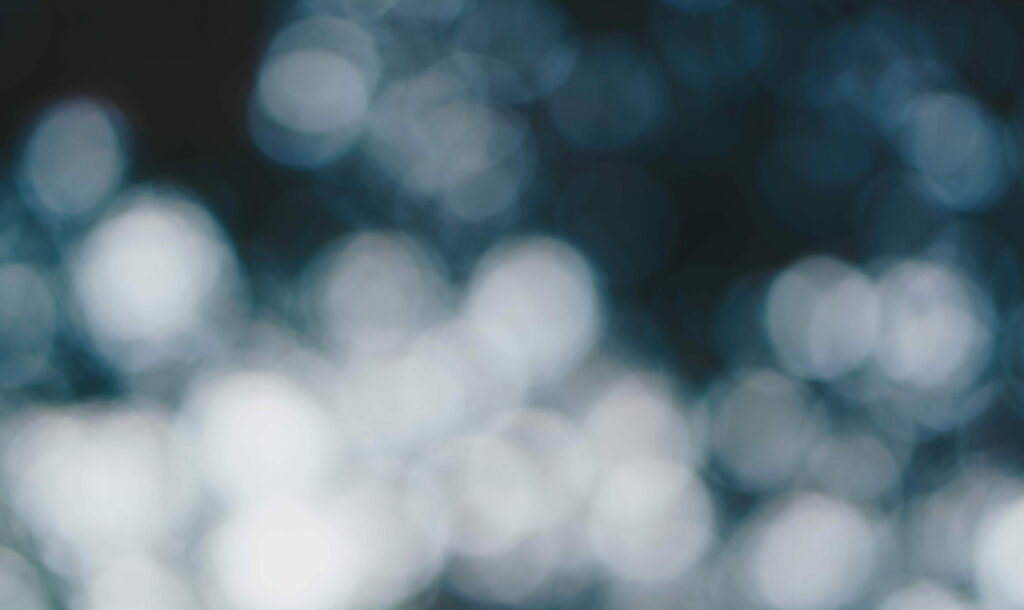 Blue bokeh wallpaper with soft glowing orbs on dark background for serene calming screens
