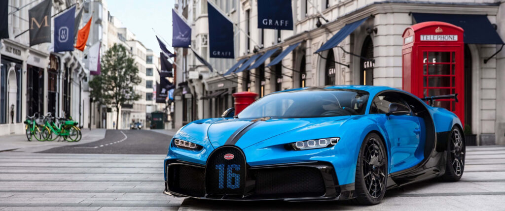 Blue Bugatti Chiron on London street with classic architecture and iconic red telephone booth Wallpaper
