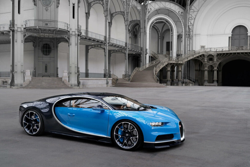 Blue Bugatti sports car in classic European town square showcasing luxury and modern design Wallpaper