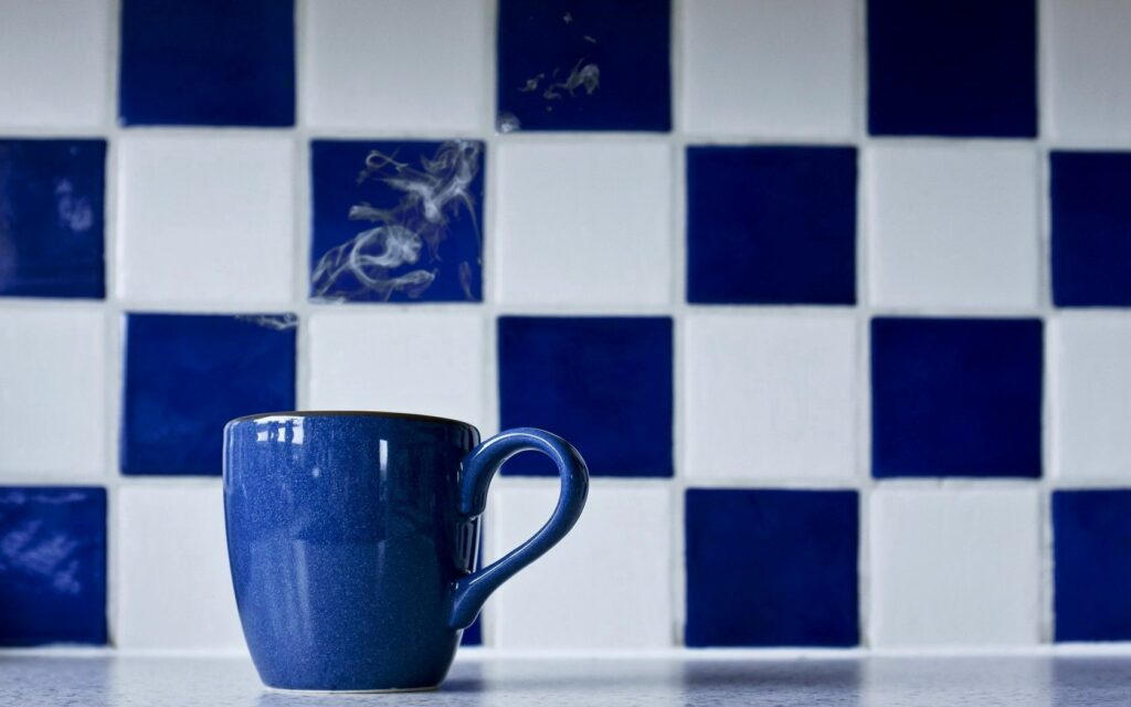 Blue Coffee Cup Wallpaper with Steam on Checkered Tiles
