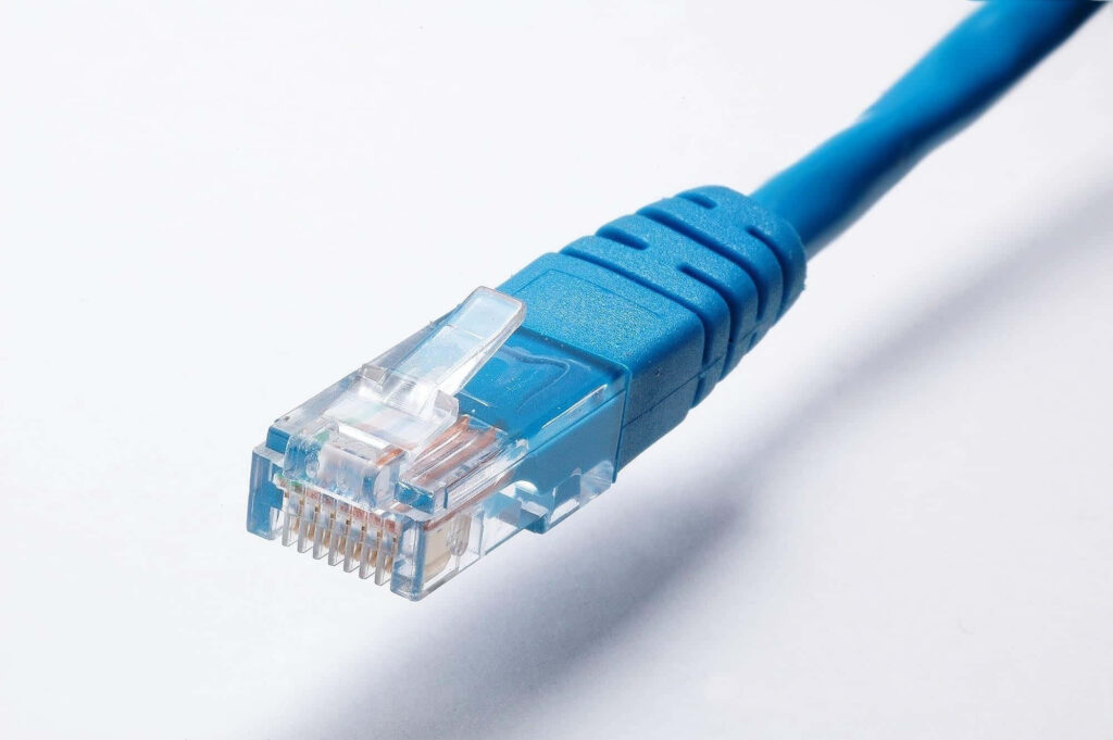 Close-up of blue Ethernet cable with clear connector on white background modern tech wallpaper