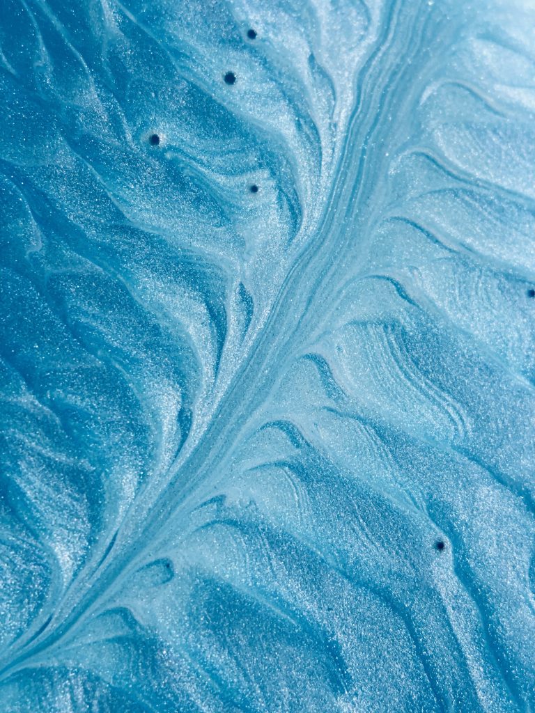 Blue glitter ripples wallpaper with shimmering sapphire and cerulean liquid swirl texture
