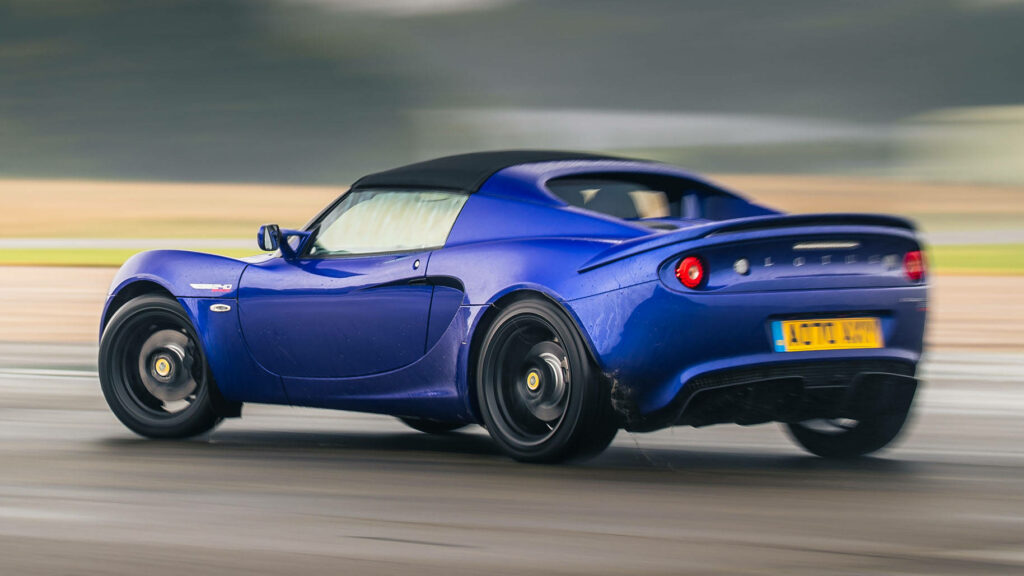 Blue Lotus Elise 220 sports car speeding on wet racetrack showcasing agility and performance wallpaper