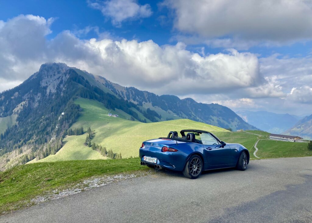 Blue Mazda MX-5 on Scenic Mountain Road - Stunning Wallpaper