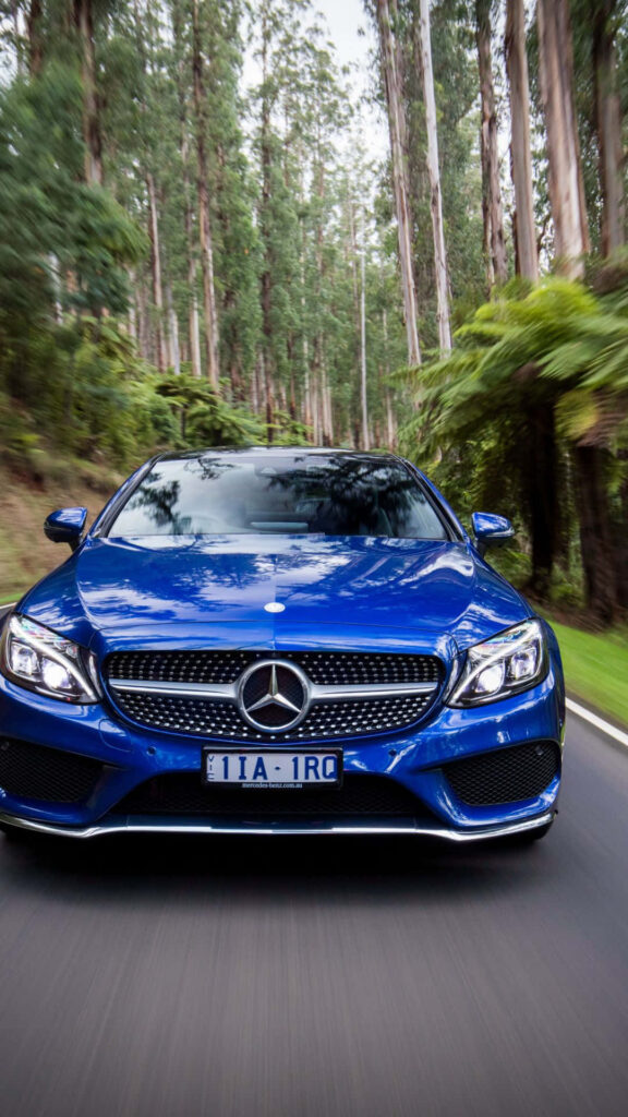 Blue Mercedes Benz driving on lush forest road vibrant detailed iPhone wallpaper background