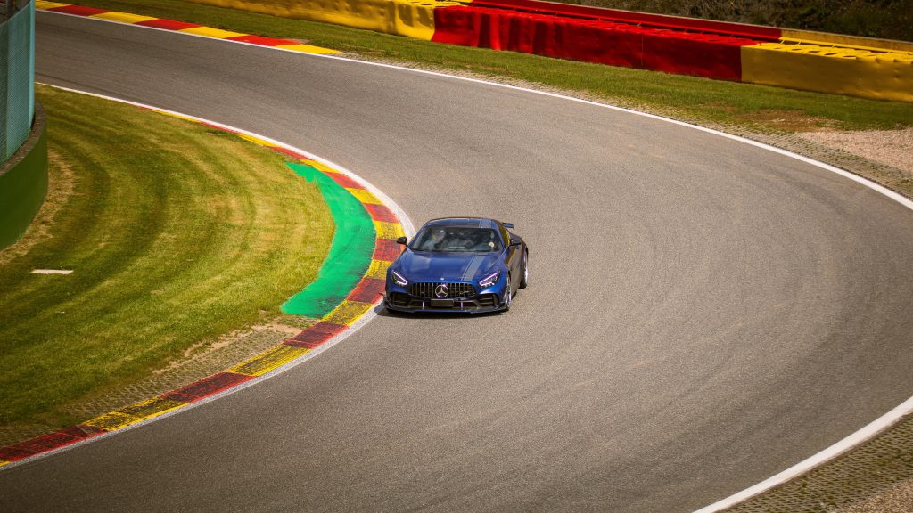 Blue Mercedes-AMG GTR racing on sunny Circuit de Spa-Francorchamps corner high-performance car Wallpaper
