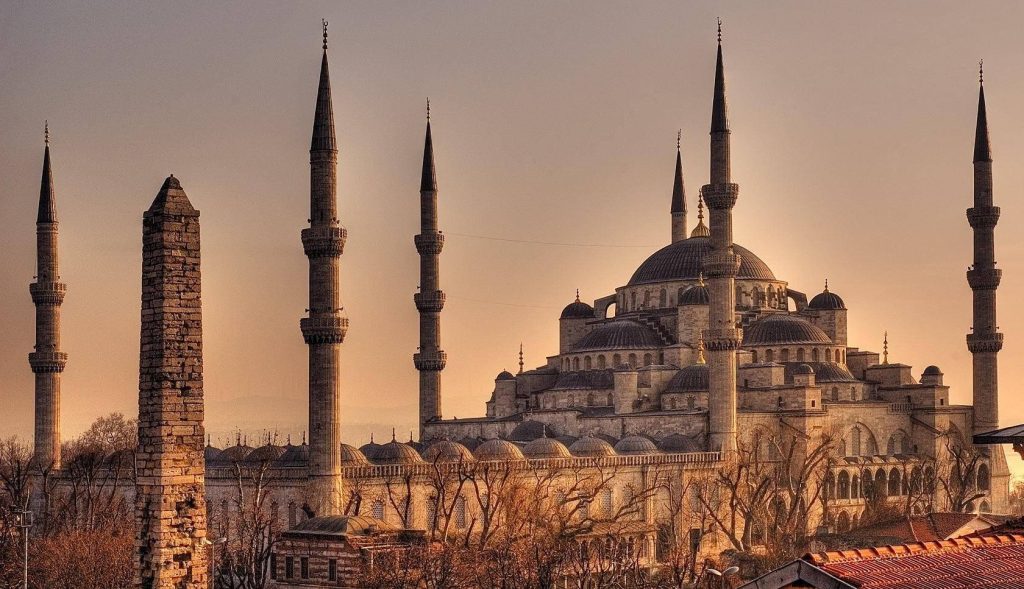 Blue Mosque Istanbul at golden hour with glowing domes six minarets and ancient obelisk Wallpaper
