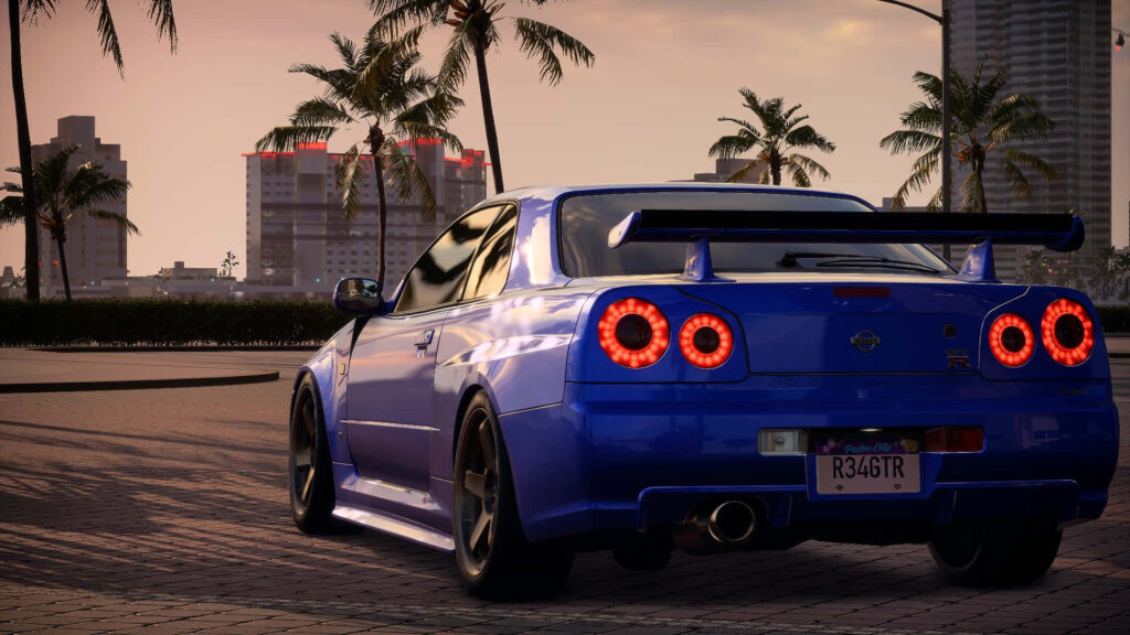 Blue Nissan Skyline R34 GTR parked under palm trees at sunset showing sporty spoiler and curves Wallpaper