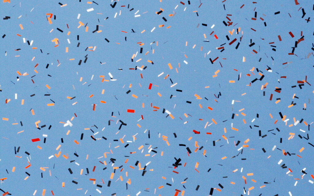 Vibrant 4K wallpaper with orange black silver confetti on soft light blue minimalist background
