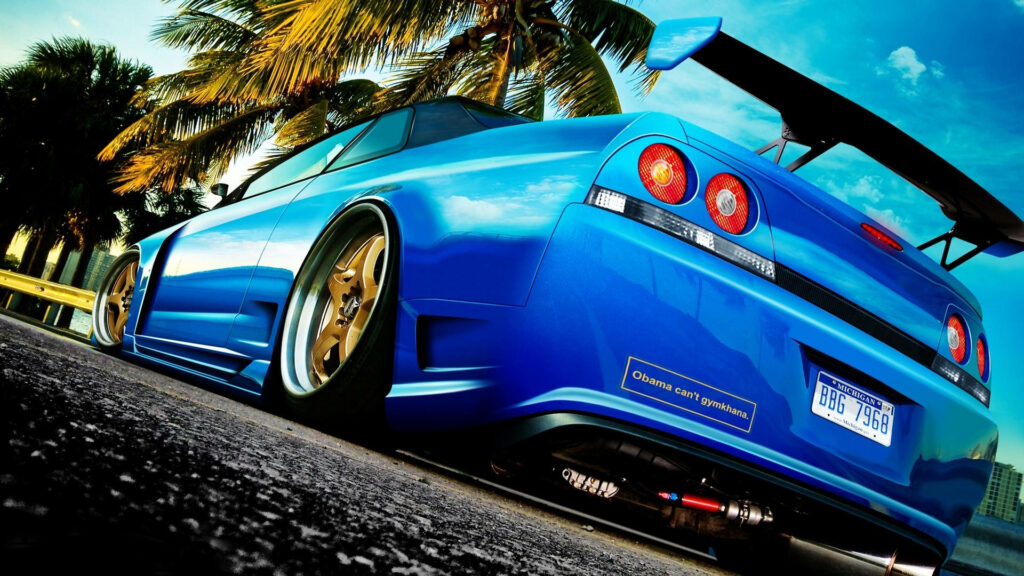 Roaming in Paradise: A Blue Nissan Skyline Cruising Through Palms Wallpaper